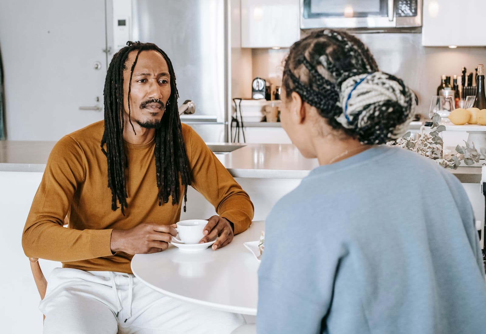 A couple talking over coffee at a kitchen table